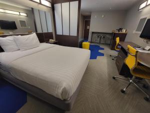 a hotel room with a bed and a desk and a chair at Microtel Inn & Suites by Wyndham Bluffs in Council Bluffs