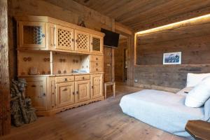 una camera con letto e parete in legno di Casa Aquila a Cortina dʼAmpezzo