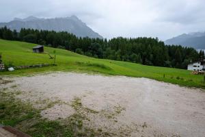 un río en un campo con montañas en el fondo en Casa Aquila, en Cortina dʼAmpezzo