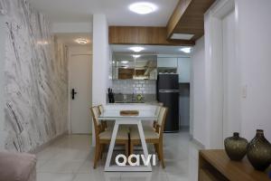 uma cozinha e sala de jantar com mesa e cadeiras em Qavi - Flat em Resort Beira Mar Cotovelo #InMare46 em Parnamirim