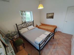 a small bedroom with a bed and a table at CostasFarmhouse, Pallini, Near Athens Airport in Pévka