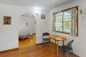 Habitación con mesa, sillas y cama en Casa Spuntino, en Placencia Village