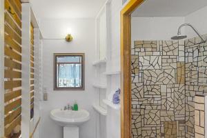 a bathroom with a sink and a toilet and a mirror at Casa Spuntino in Placencia Village