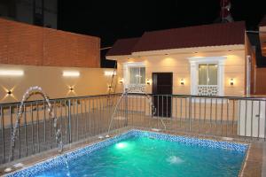 a swimming pool with water fountains in front of a house at شاليهات التميز الراقي in Al Hada