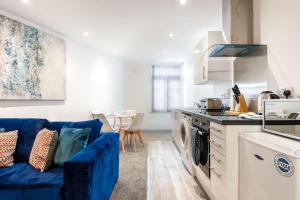 Modern Budget Apartment in Central Doncaster في دونكاستير: غرفة معيشة مع أريكة زرقاء في مطبخ