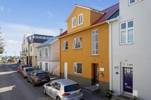 una fila de casas en una calle con coches aparcados en Venture Vacation-Reykjavík Center, King bed, 65" TV with Netflix en Reikiavik