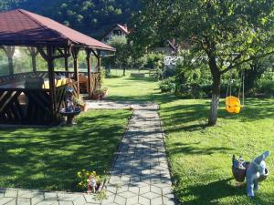 a garden with a stone path and a gazebo at Casa Zorilor in Şugag