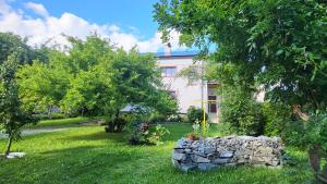 a house with a stone wall in a yard at Apartmán Husovka Bruntál - pokoj POLLY in Bruntál