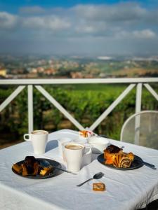 a table with two plates of food and cups of coffee at La Vista Agriturismo Boutique in Ariccia