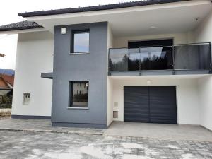 a white house with a black garage door at Happy Place in Ig