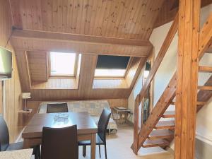 帕斯底拉卡薩的住宿－2 ESCALES CONFORT，一间带桌椅和木制天花板的用餐室