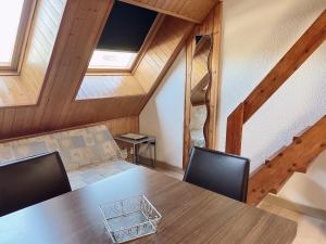 a table and chairs in a room with wooden ceilings at 2 ESCALES CONFORT in Pas de la Casa