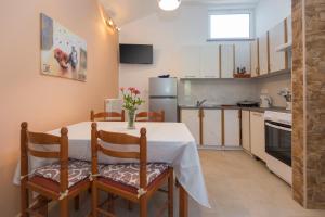 una cocina con mesa con 2 sillas y mesa y una cocina con en Apartman Ana, en Labin