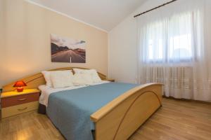 - une chambre avec un lit bleu et une fenêtre dans l'établissement Apartman Ana, à Labin