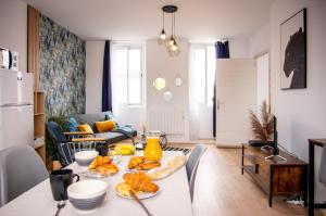 a kitchen and living room with a table with food on it at DUPLEX COCOON - 10 MIN DE BLAYE - 20 MIN CNPE - WiFi - TV HD in Saint-Seurin-de-Cursac