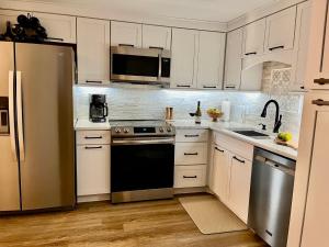 a kitchen with white cabinets and a stainless steel refrigerator at On top of the world at Sugar Top Resort in Sugar Mountain