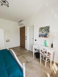 - une chambre avec un lit bleu et un bureau blanc dans l'établissement Villa Tadina, à Gualdo Tadino