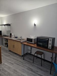 uma cozinha com uma mesa com um micro-ondas e um balcão em Studio em Fains-les-Sources