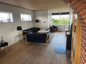 a living room with a couch and a table at 200 m til havet - fri adgang til svømmehal in Thyborøn