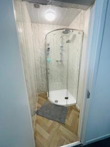 a shower with a glass door in a bathroom at Bethel Apartments in Leeds