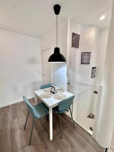 a dining room with a white table and blue chairs at Loft Moderno en Madrid in Madrid