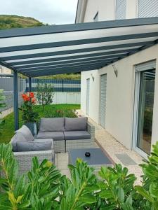 a pergola over a patio with couches and a table at Ferienwohnung Kleb in Malterdingen