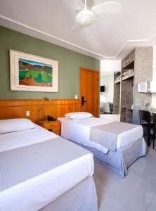 um quarto de hotel com duas camas e uma cozinha em Savassinho Hotel & Residence em Belo Horizonte