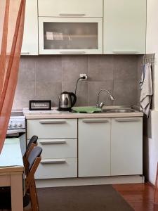 a kitchen with white cabinets and a sink at Q tak in Sarajevo