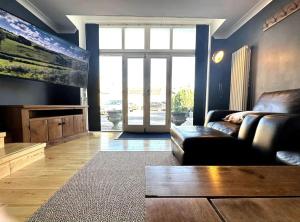 a living room with a couch and a large window at Cosy & quirky cottage in the heart of Bakewell. in Bakewell