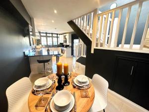 a dining room with a table with chairs and a staircase at Cosy & quirky cottage in the heart of Bakewell. in Bakewell
