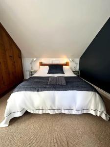 een slaapkamer met een groot bed met een zwarte muur bij Cosy & quirky cottage in the heart of Bakewell. in Bakewell