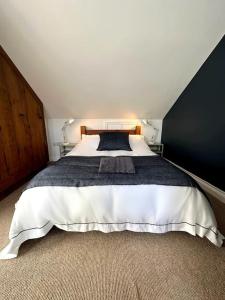 a bedroom with a large bed with a black wall at Cosy & quirky cottage in the heart of Bakewell. in Bakewell