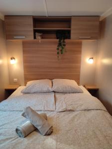 ein großes Bett mit zwei Kissen darüber in der Unterkunft Mobil-home climatisé 6 pers en Ardèche in Orgnac-lʼAven