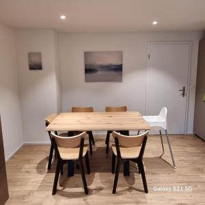 una mesa de madera y sillas en una habitación en Mountain-Lake Apartment 2 en Wilderswil