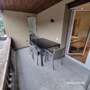 einen schwarzen Tisch und Stühle auf dem Balkon in der Unterkunft Mountain-Lake Apartment 2 in Wilderswil