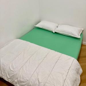 een bed met twee witte kussens erop bij Appartement confortable et complet in Clichy