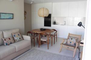 a living room with a couch and a table and chairs at Seaside Fort House, T2 Tavira – Cabanas de Tavira in Cabanas de Tavira