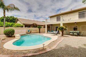 a swimming pool in the backyard of a house with a patio at Spacious Goodyear Retreat - Walk to Wigwam! in Goodyear