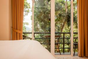 a bedroom with a bed and a large window at ANILAD Kandy in Kandy