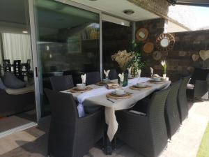 una mesa con sillas y un mantel blanco. en Deluxe Villa with private pool El Duque, en Adeje