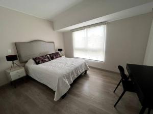 a bedroom with a bed and a window and a desk at MLA apartments - Reducto 360 in Lima