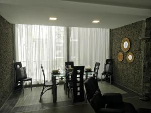 d'une salle à manger avec des chaises, une table et une fenêtre. dans l'établissement Deluxe Villa with private pool El Duque, à Adeje