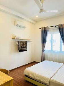 a bedroom with a bed and a table and a window at Sofea Mutiara Homestay Ipoh in Ipoh