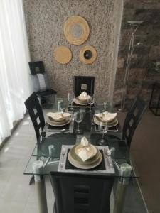 une table en verre avec des chaises et des assiettes de nourriture dans l'établissement Deluxe Villa with private pool El Duque, à Adeje