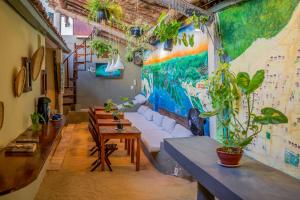 LaTaperaJeri Hostel في يريكوكورا: غرفة معيشة مع أريكة وطاولات ونباتات