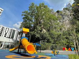 um parque infantil com um escorrega amarelo num parque em Ipoh Luxurious Homestay by Comfort Home em Ipoh