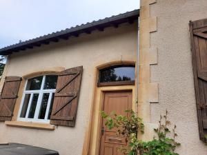 uma casa com uma porta de madeira e janelas em Chez Line et Pierre: Appartement spacieux, lumineux et équipé em La Bastide-de-Sérou