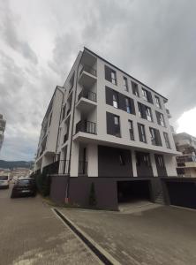 a large white apartment building with a parking lot at The Nest in Floreşti