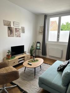 a living room with a couch and a table at Bienvenu à l’appart bien-être in Souvigny