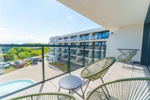 a balcony with chairs and a view of a building at Apartament Westin House 303 in Kołobrzeg